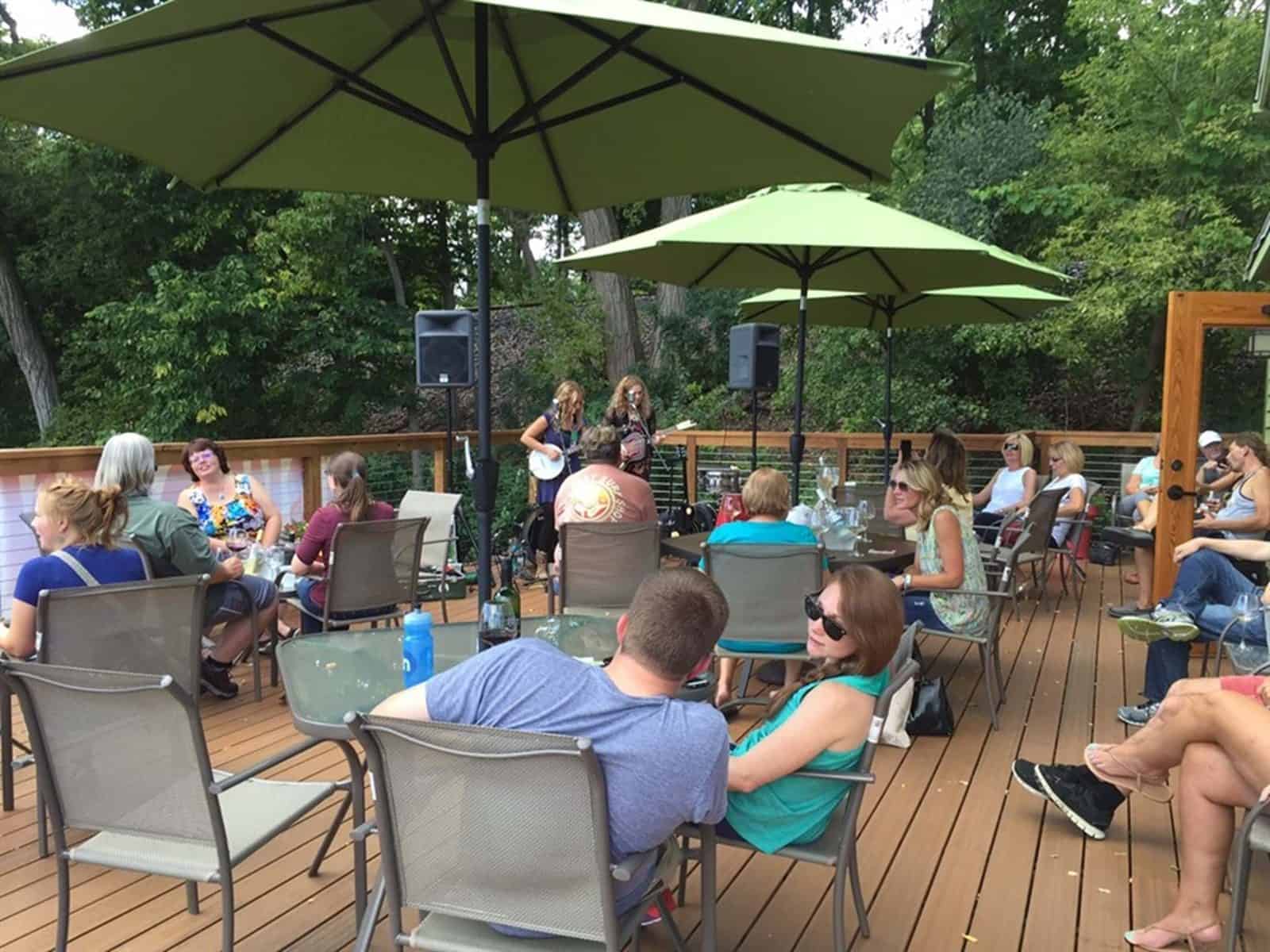 Live music and wine tasting on an outdoor patio during the Village of East Davenport Wine Walk